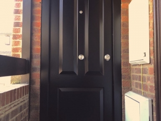 Police door jammer resistant secure steel front door fitted in a block of flats.