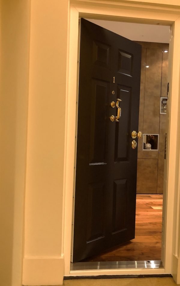 Solid security door in classic design and painted in black.
