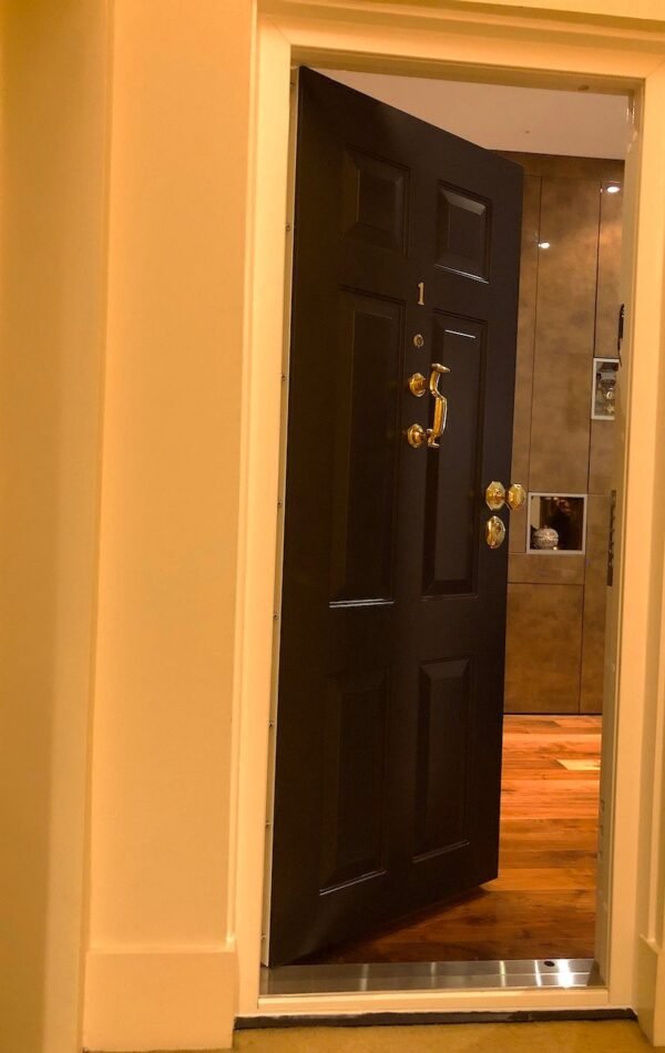 Solid security door in classic design and painted in black.