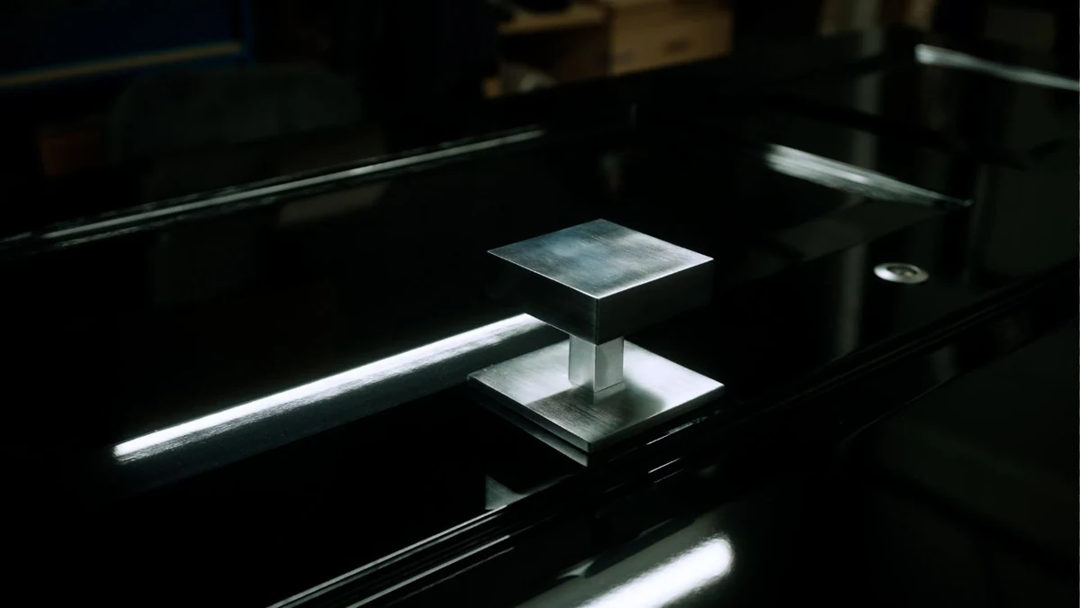 Square brushed-metal door knocker on a bespoke black security front door